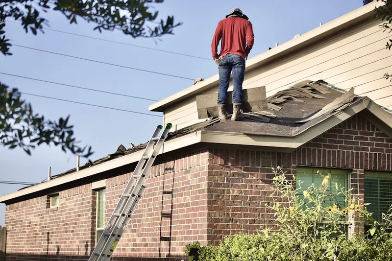 Professional roofer working on a residential roof in Belle Meade West